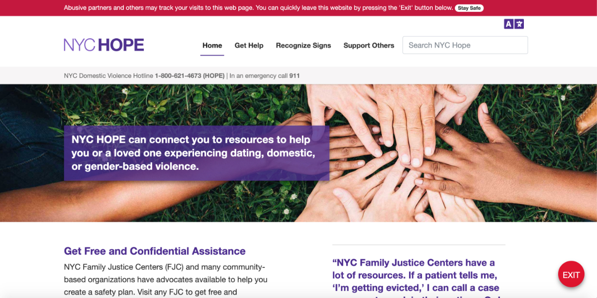 A group of people join hands in a field of grass